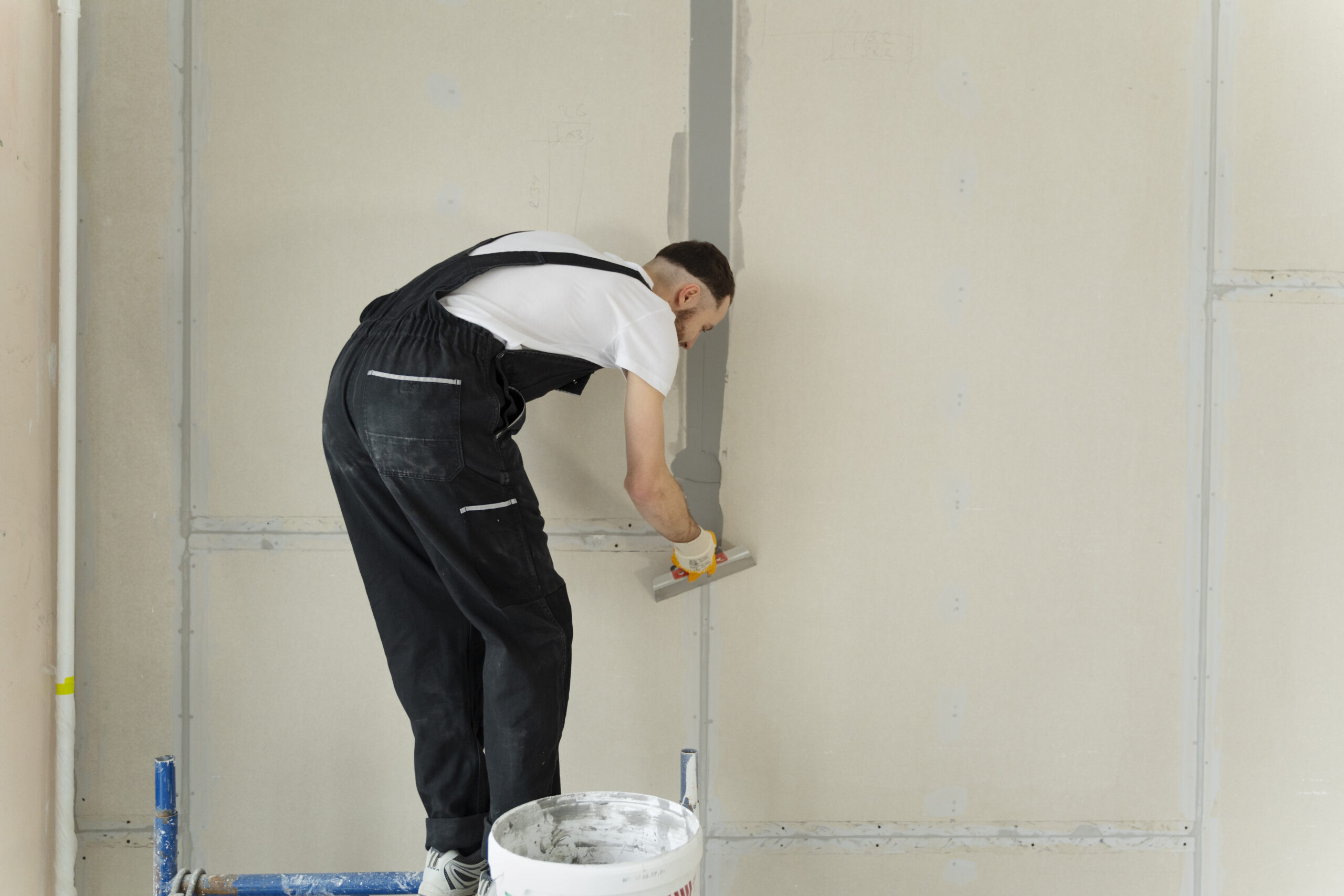 full shot construction worker using plastering trowel